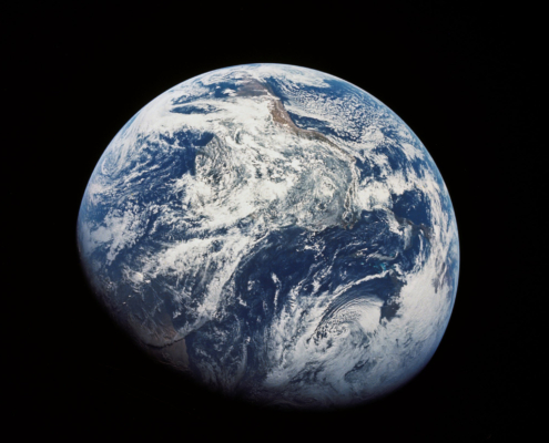 One of the first images taken by humans of the whole Earth. Photographed by the crew of Apollo 8 (probably by Bill Anders) the photo shows the Earth at a distance of about 30,000 km. South is at the top, with South America visible at the covering the top half center, with Africa entering into shadow. North America is in the bottom right.